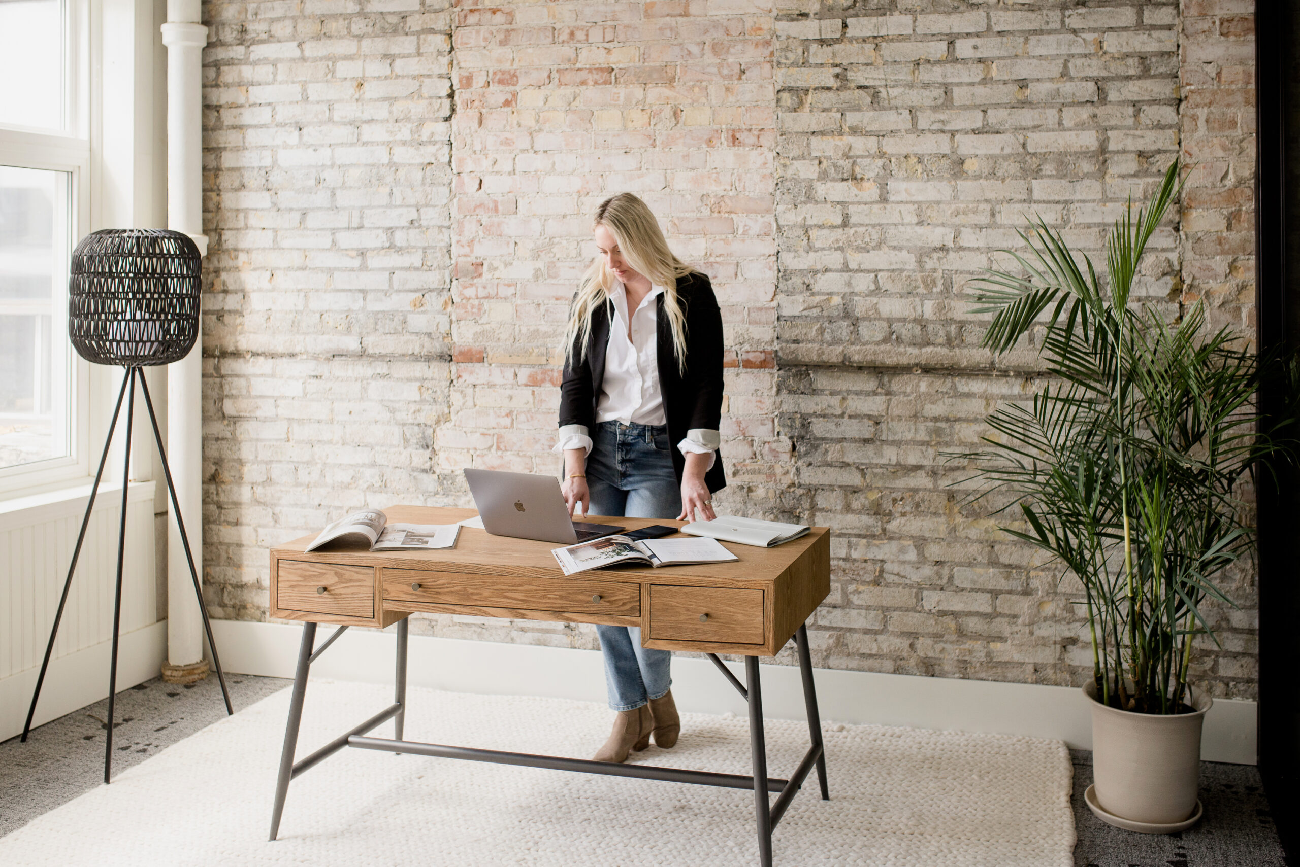 woman standing at a desk reading on a laptop about Pinterest for Ecommerce Businesses